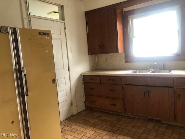 2117 Maple Ave NE, Canton, OH 44714 - kitchen with a sink, freestanding refrigerator, light countertops, tasteful backsplash, and light tile patterned flooring