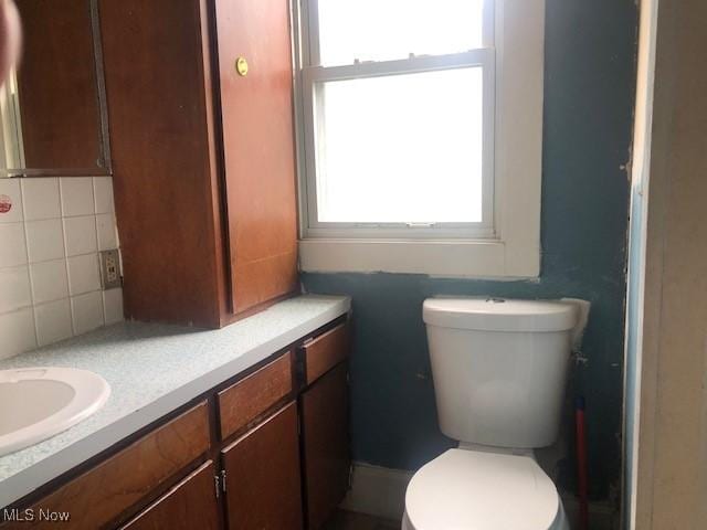 2117 Maple Ave NE, Canton, OH 44714 - bathroom with toilet, tasteful backsplash, and vanity