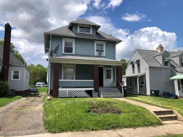 2117 Maple Ave NE, Canton, OH 44714 - traditional style home with covered porch, a front lawn, and central AC