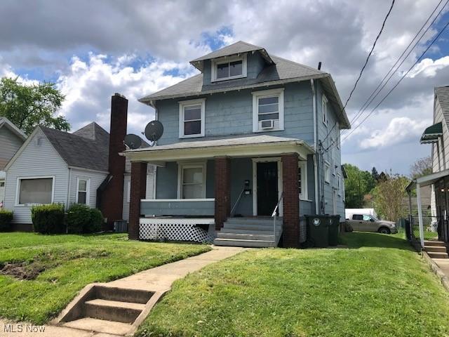 2117 Maple Ave NE, Canton, OH 44714 - traditional style home featuring covered porch, a front yard, and cooling unit
