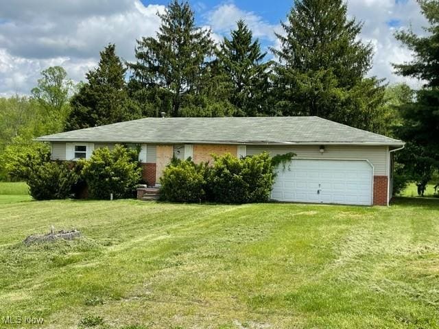 362 Jettie Ave NE, East Canton, OH 44730 - view of front of house featuring a garage, a front lawn, and brick siding