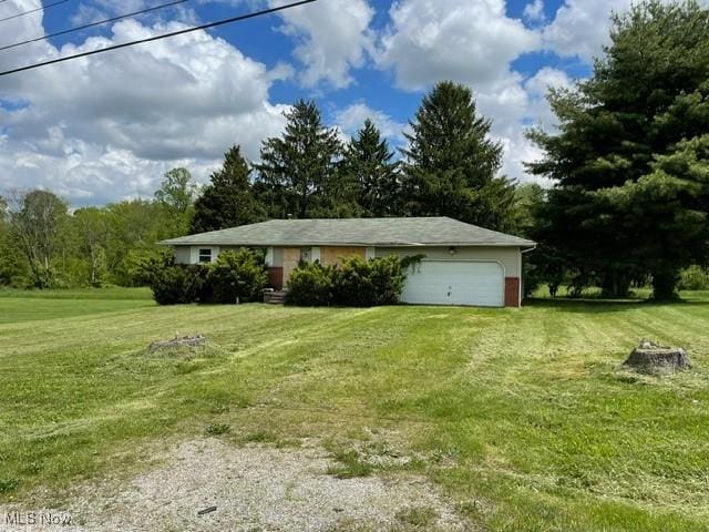 362 Jettie Ave NE, East Canton, OH 44730 - view of front of property with a garage, a front lawn, driveway, and view of wooded area