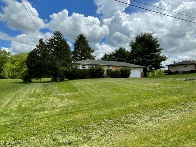 362 Jettie Ave NE, East Canton, OH 44730 - view of green lawn with an attached garage