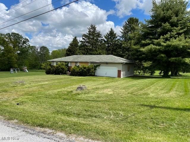 362 Jettie Ave NE, East Canton, OH 44730 - view of grassy yard featuring a garage and view of scattered trees