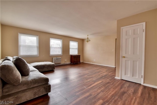 living room with dark wood finished floors, healthy amount of natural light, a wall mounted air conditioner, and baseboards