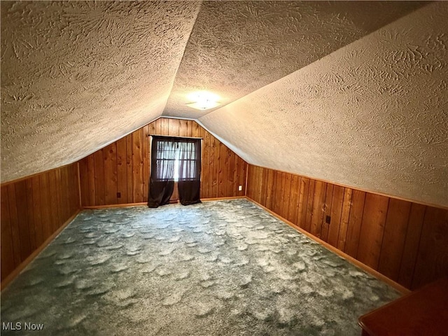 bonus room featuring vaulted ceiling, carpet floors, and wood walls