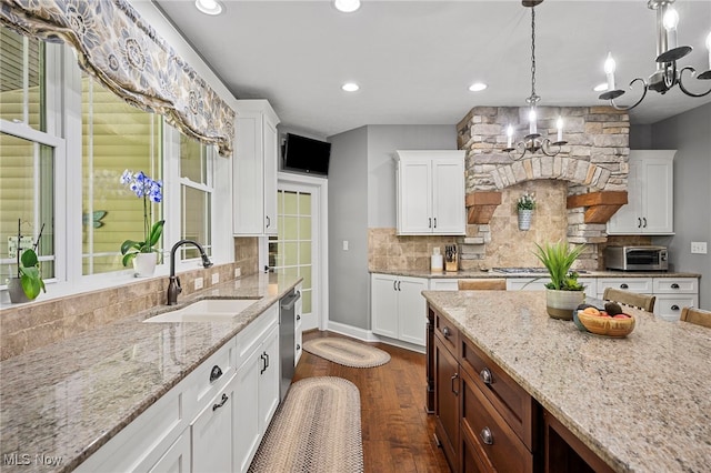 15020 Steelhead Run, Chardon, OH 44024 - kitchen featuring a sink, a chandelier, stainless steel dishwasher, decorative backsplash, and white cabinets