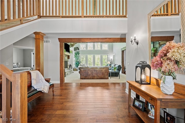 15020 Steelhead Run, Chardon, OH 44024 - living area featuring a towering ceiling, hardwood / wood-style floors, a fireplace with raised hearth, and baseboards