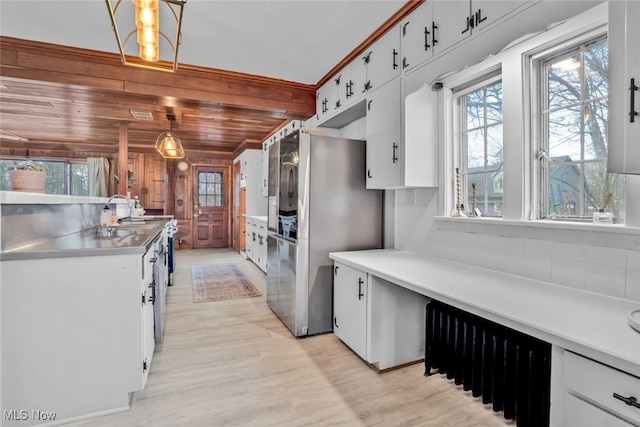 555 E Milton St, Alliance, OH 44601 - kitchen with stainless steel countertops, freestanding refrigerator, light wood-style flooring, white cabinets, and pendant lighting