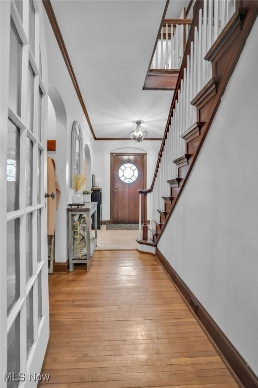 555 E Milton St, Alliance, OH 44601 - foyer entrance with arched walkways, ornamental molding, stairway, baseboards, and hardwood / wood-style flooring