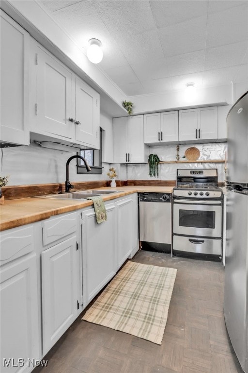 555 E Milton St, Alliance, OH 44601 - kitchen with appliances with stainless steel finishes, a sink, white cabinetry, and wood counters