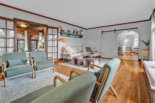555 E Milton St, Alliance, OH 44601 - living room with arched walkways, wood-type flooring, a barn door, baseboards, and crown molding