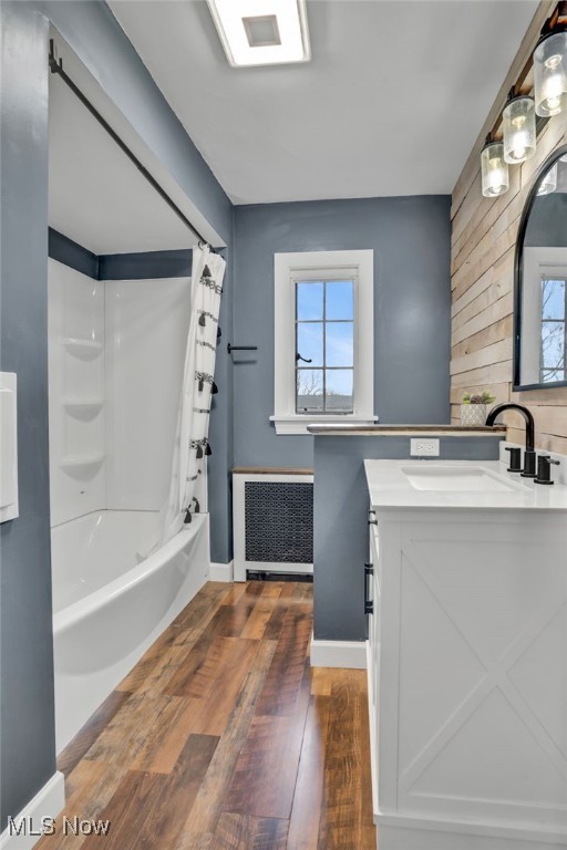 555 E Milton St, Alliance, OH 44601 - bathroom featuring radiator heating unit, hardwood / wood-style floors, vanity, shower / tub combo, and wooden walls