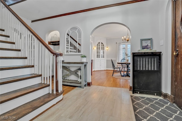 555 E Milton St, Alliance, OH 44601 - foyer entrance featuring arched walkways, stairs, crown molding, wood finished floors, and a chandelier