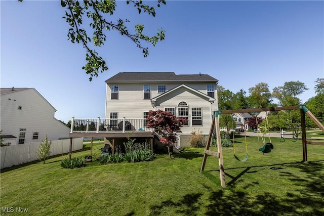 rear view of property with a playground and a wooden deck