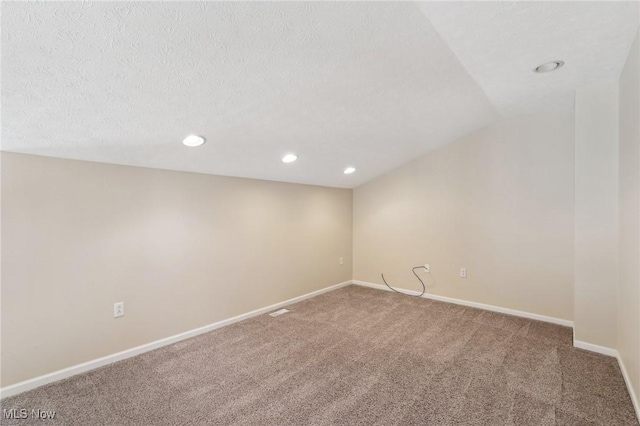 carpeted spare room featuring baseboards, recessed lighting, and a textured ceiling