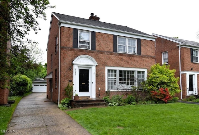 3622 Lynnfield Rd, Shaker Heights, OH 44122 - view of front of home featuring brick siding, a chimney, a front lawn, an outbuilding, and a detached garage