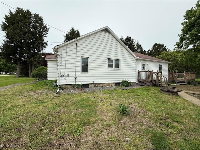 back of house featuring a deck and a yard