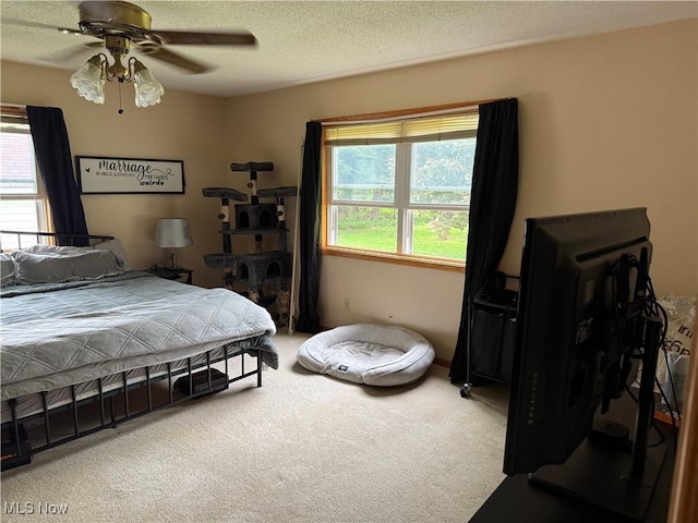 bedroom with carpet floors, a textured ceiling, and a ceiling fan