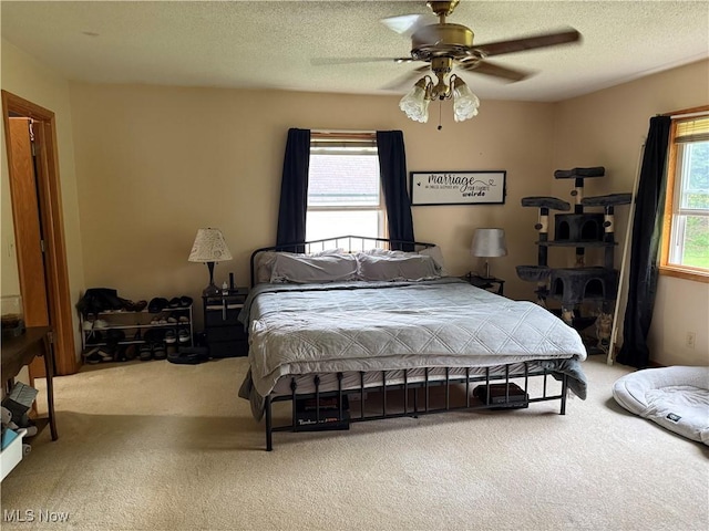 bedroom with carpet flooring, a ceiling fan, and a textured ceiling