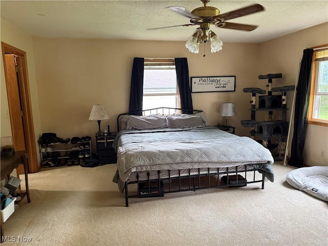 bedroom featuring carpet floors, a ceiling fan, and a textured ceiling