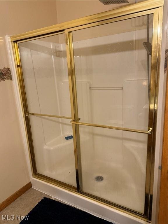 bathroom with a stall shower and baseboards