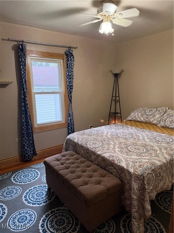 bedroom with wood finished floors, ceiling fan, and baseboards