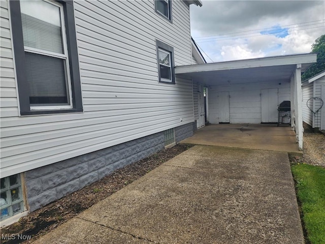 1327 Orange St, Coshocton, OH 43812 - view of home's exterior featuring an attached carport and concrete driveway