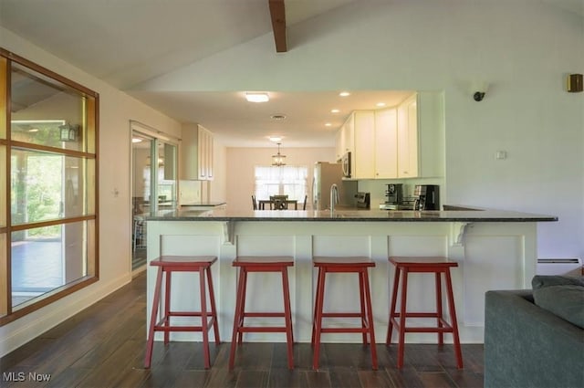 31 Garden Park Dr, Chagrin Falls, OH 44022 - kitchen featuring a peninsula, white cabinetry, dark wood finished floors, a kitchen breakfast bar, and recessed lighting