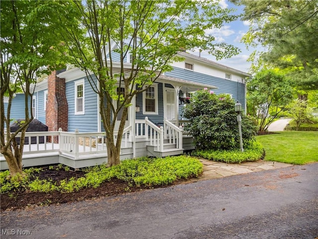 view of front of house with covered porch and a front lawn
