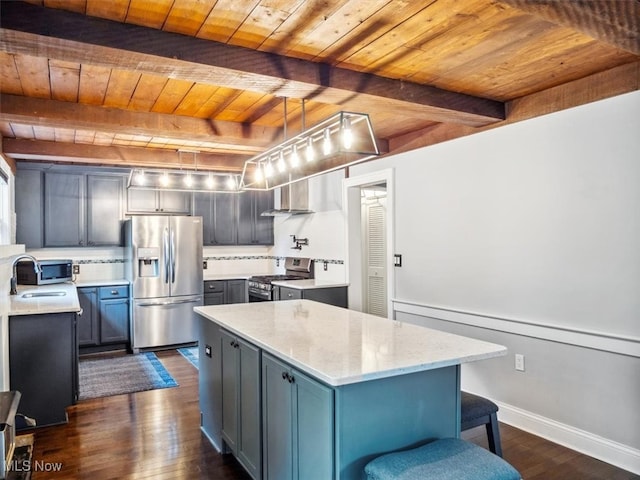 kitchen featuring appliances with stainless steel finishes, wooden ceiling, beamed ceiling, dark wood-type flooring, and a center island