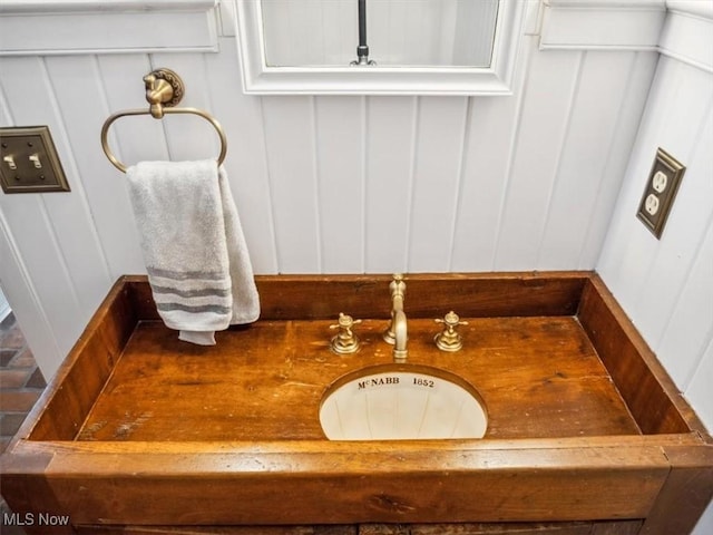 bathroom featuring a sink and a decorative wall