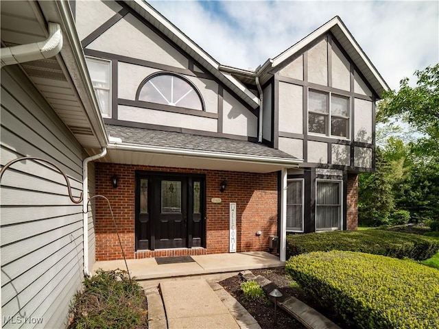 21428 Montclare Blvd, Strongsville, OH 44149 - view of exterior entry with brick siding, stucco siding, a shingled roof, and covered porch