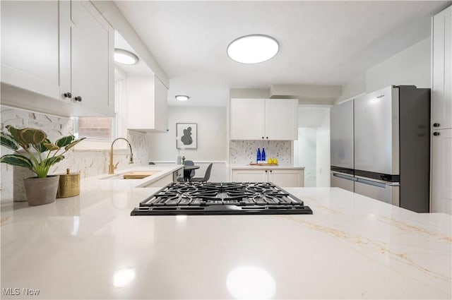 2400 Saybrook Rd, University Heights, OH 44118 - kitchen with appliances with stainless steel finishes, a sink, white cabinetry, decorative backsplash, and light stone counters