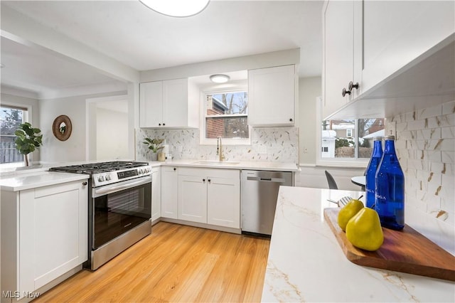 2400 Saybrook Rd, University Heights, OH 44118 - kitchen featuring stainless steel appliances, a sink, a peninsula, light wood-style flooring, and white cabinets