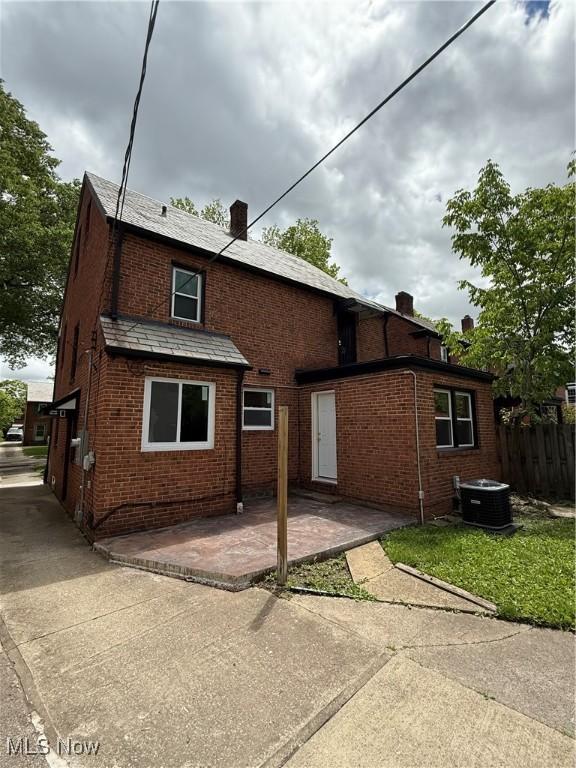 2400 Saybrook Rd, University Heights, OH 44118 - back of house featuring a chimney, a patio, brick siding, and central AC