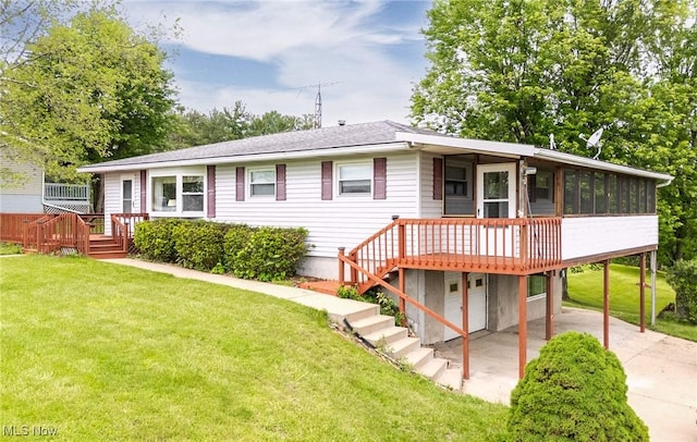 1655 Calder Ridge Rd, Belpre, OH 45714 - view of front facade with a sunroom, a wooden deck, driveway, a front lawn, and a patio