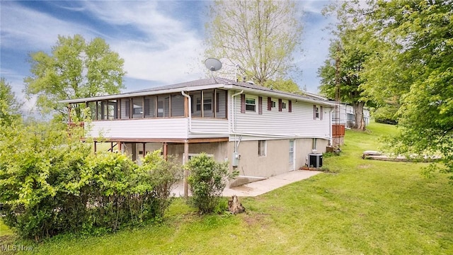 1655 Calder Ridge Rd, Belpre, OH 45714 - rear view of property with central AC unit, a sunroom, and a yard
