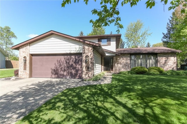 view of front of property featuring brick siding, an attached garage, driveway, and a front yard