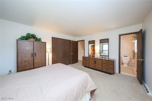 bedroom with light carpet and ensuite bath