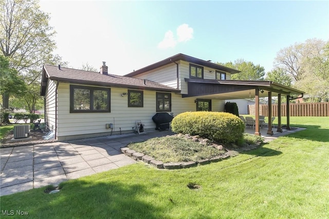 view of front facade with a patio area, cooling unit, and a chimney