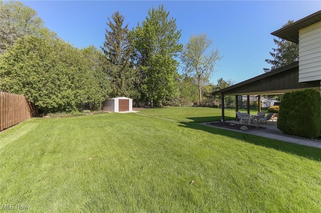 view of yard featuring a storage unit, a patio area, and an outdoor structure