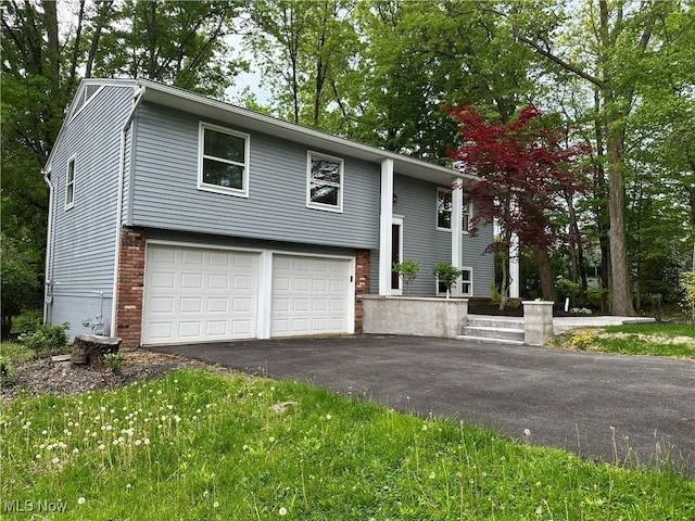 9744 Andrea Dr, Concord, OH 44060 - raised ranch with asphalt driveway, a garage, and brick siding
