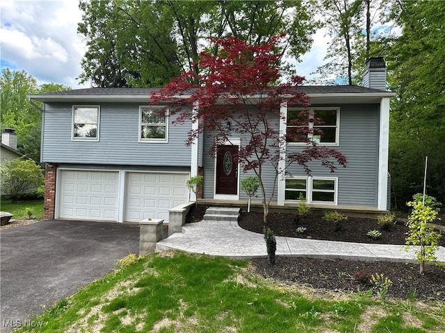 9744 Andrea Dr, Concord, OH 44060 - raised ranch with asphalt driveway, a garage, and a chimney