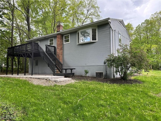9744 Andrea Dr, Concord, OH 44060 - rear view of property featuring a deck, a chimney, central AC unit, a lawn, and stairway