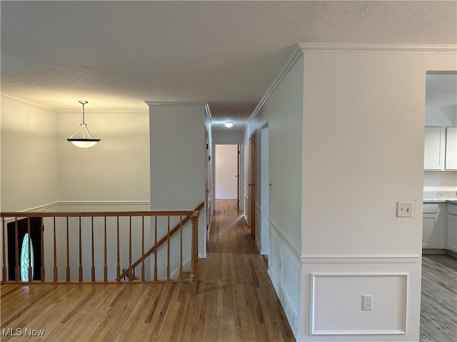 9744 Andrea Dr, Concord, OH 44060 - hallway with crown molding, wood finished floors, an upstairs landing, and a textured ceiling