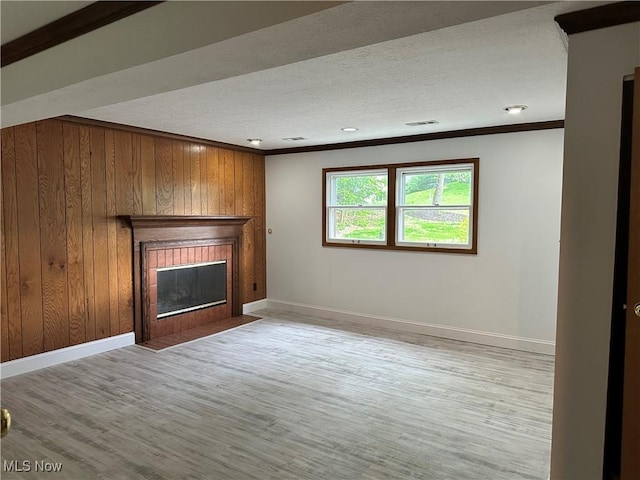 9744 Andrea Dr, Concord, OH 44060 - unfurnished living room with crown molding, baseboards, wooden walls, a fireplace with flush hearth, and wood finished floors