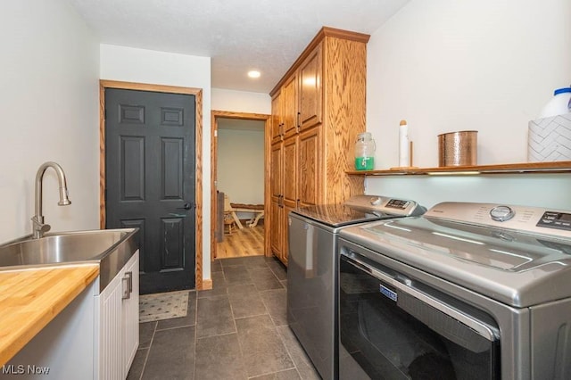 laundry room with cabinet space, washing machine and clothes dryer, and dark tile patterned flooring