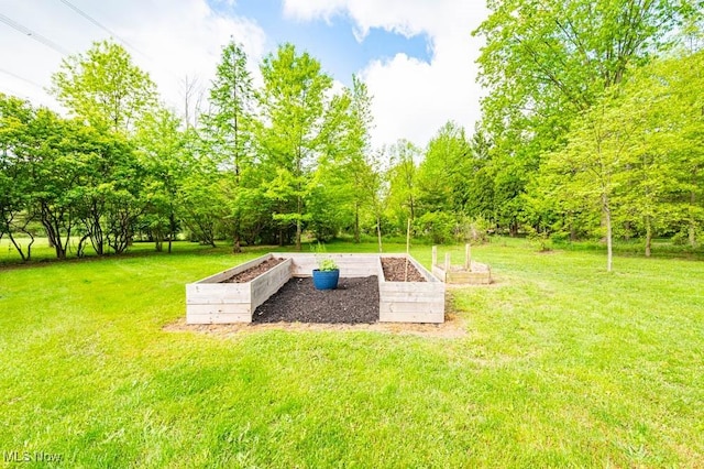 view of green lawn featuring a vegetable garden