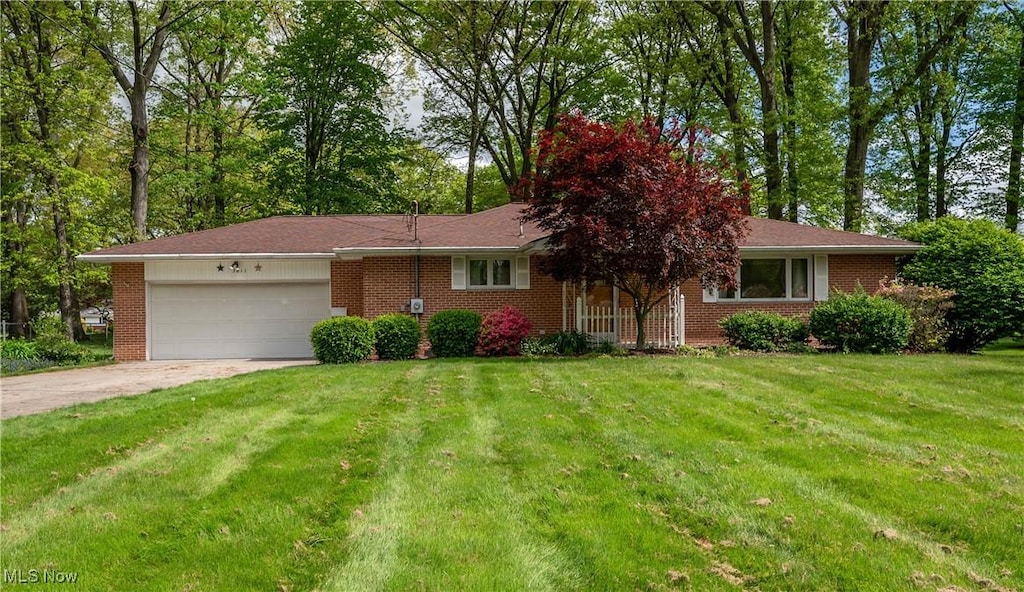 3011 Hoffman Cir NE, Warren, OH 44483 - view of front facade featuring an attached garage, driveway, a front yard, and brick siding